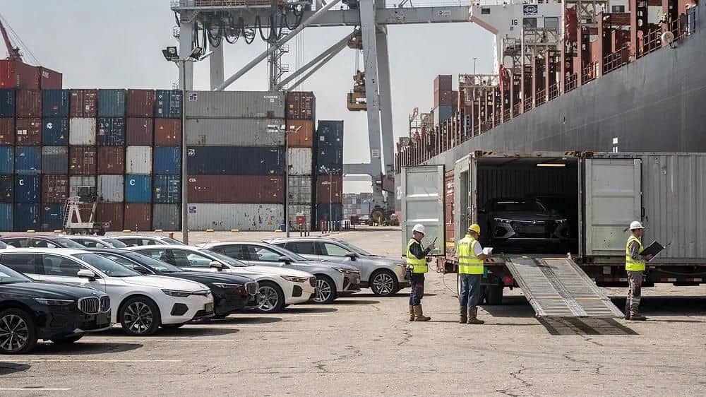 Vehicles being loaded into a container at the port